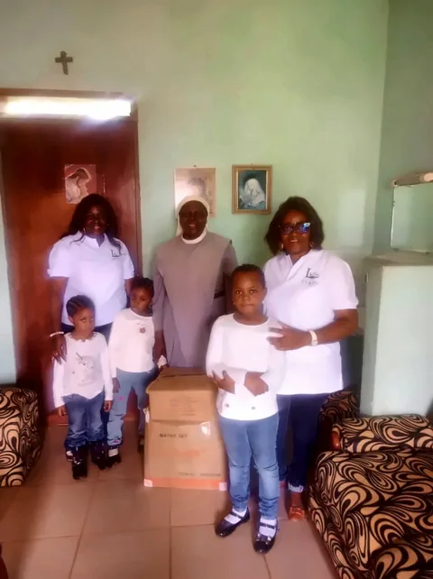 Photo de groupe au monastère, avec les cartons de fournitures scolaires