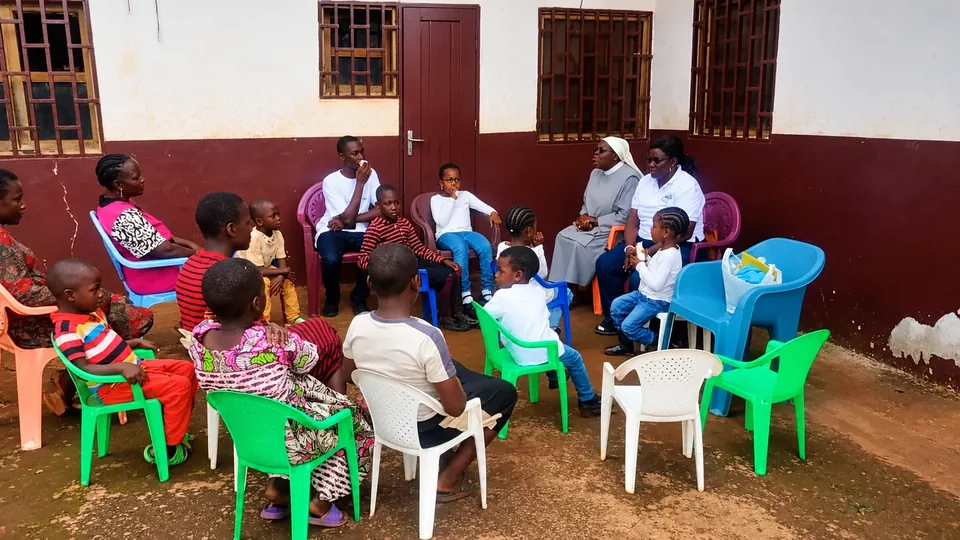 Réunion communautaire dans la cour : les enfants, les sœurs et les membres de la fondation réunis